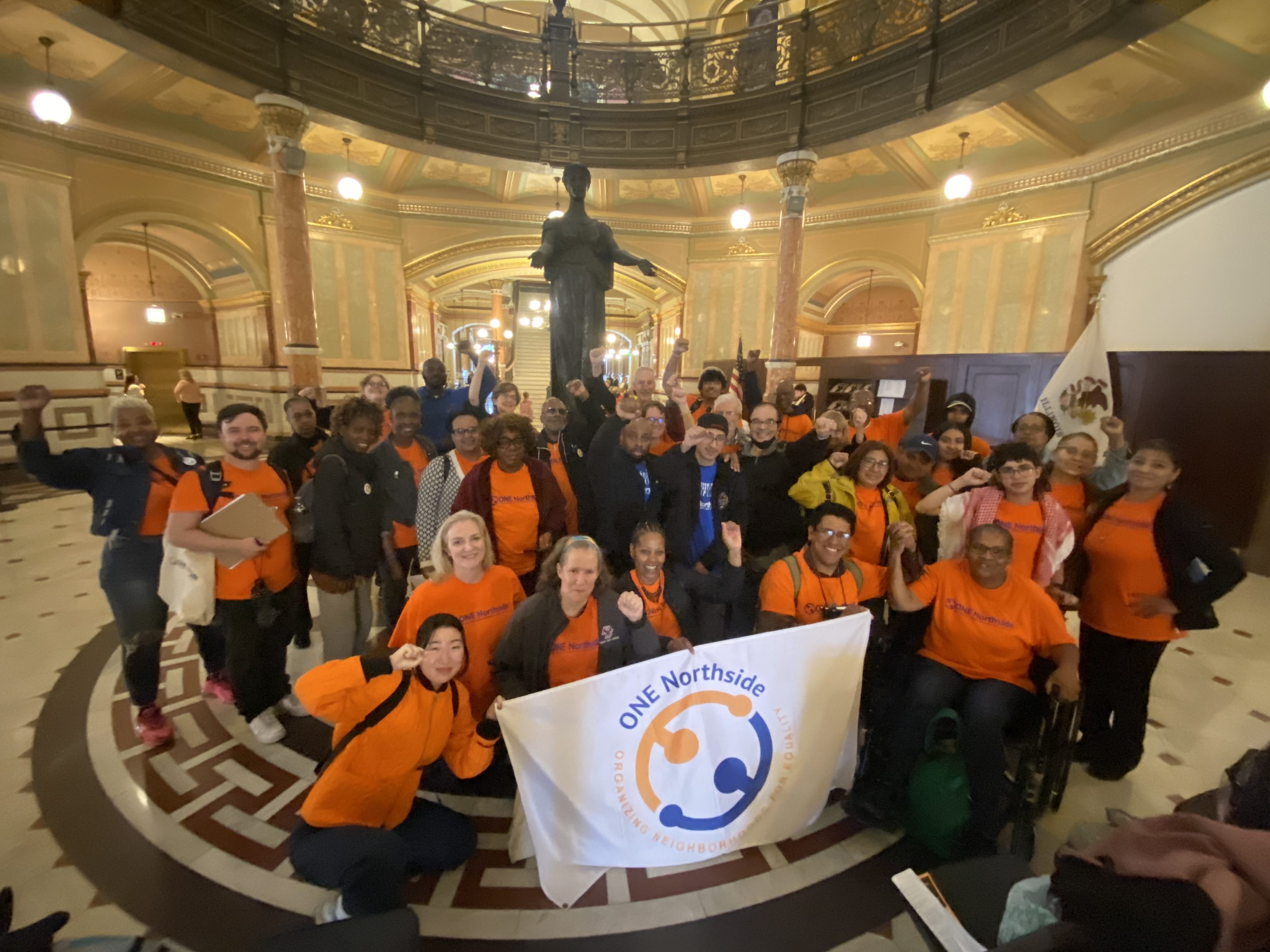 a large group in the capitol with a one northside banner